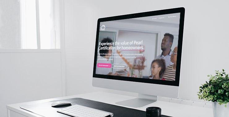 Screenshot of the new Pearl Certification homepage on a monitor in a white, airy room