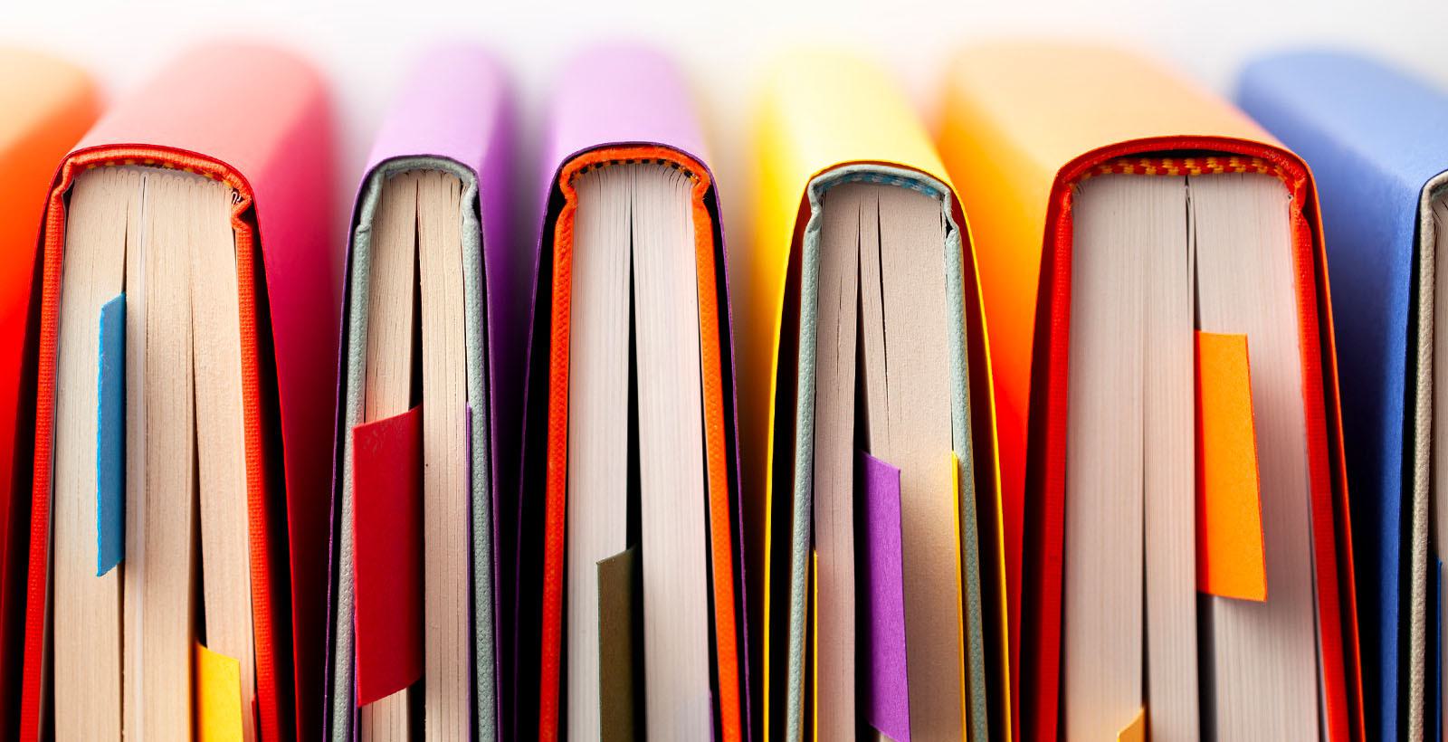 A row of colourful books with bookmarks