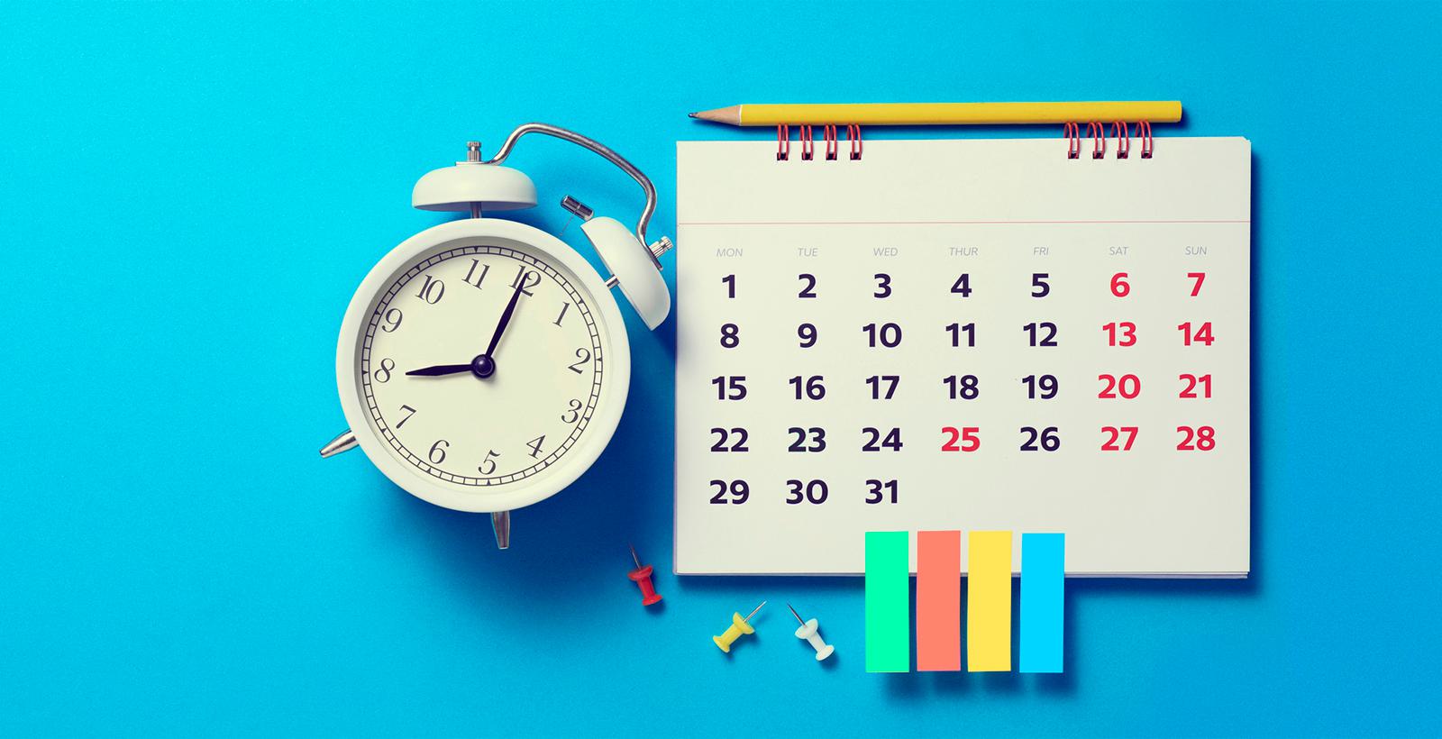 A white alarm clock next to a calendar on a blue background. A yellow pencil lies on the calendar with sticky notes and pushpins below.