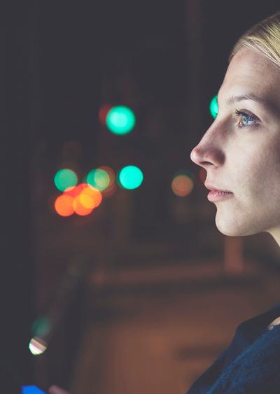 Woman touching a screen at night