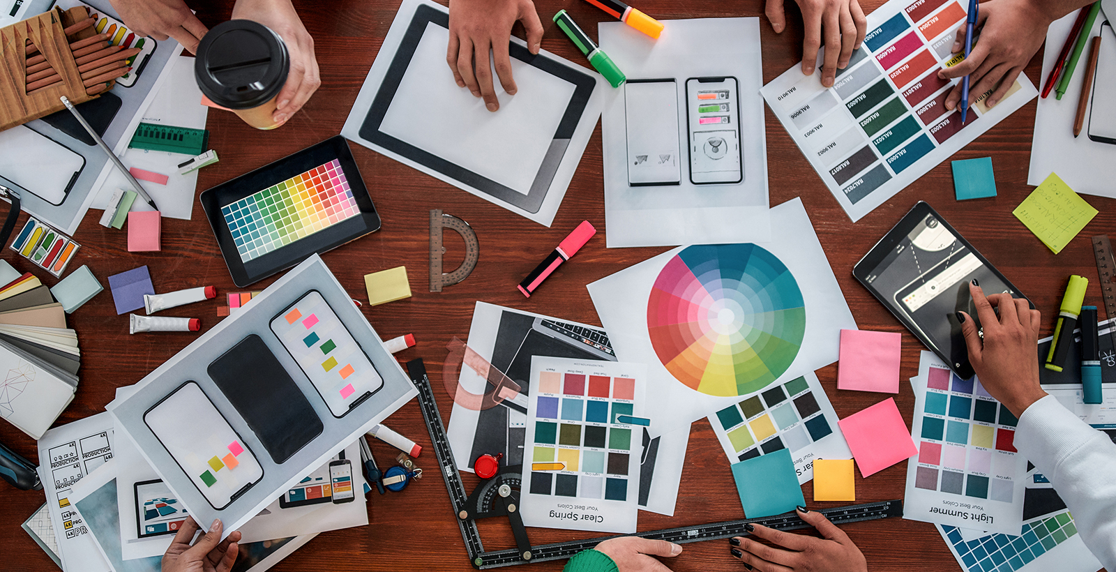 Colourful brand design mockups strewn across a table