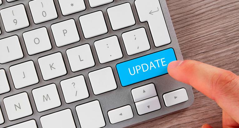 A keyboard with someone's finger hovering over the word UPDATE