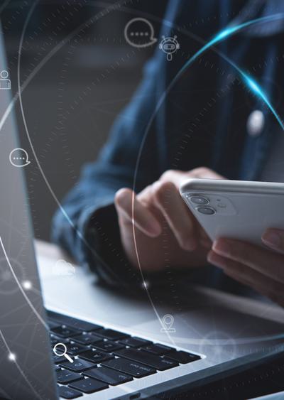 Woman using mobile phone and laptop computer.