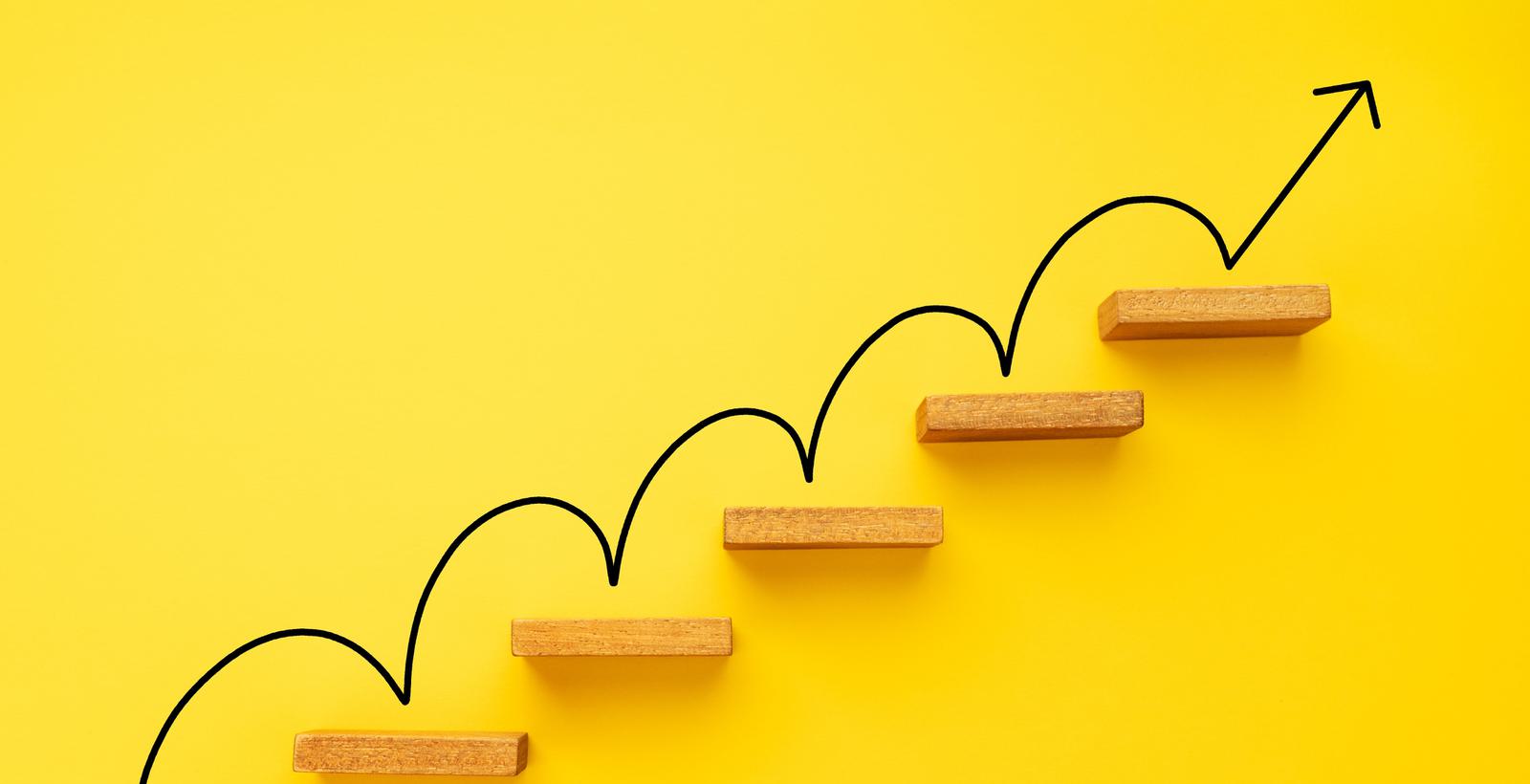 An arrow climbing stairs on a yellow background.